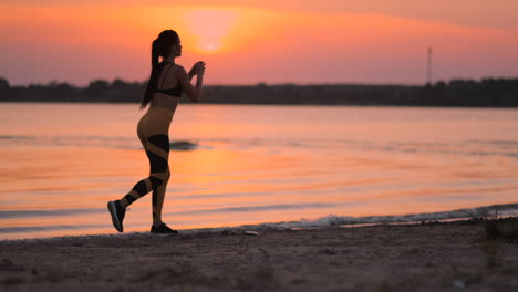 Eine-Frau-Macht-Sit-ups-Bei-Sonnenuntergang-Am-Strand-In-Zeitlupe.-Trainieren-Sie-Die-Muskeln-Der-Hüfte